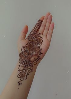 a woman's hand with a henna tattoo on her left arm and wrist