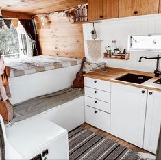 a kitchen area with sink, refrigerator and stove top oven in a small cabin style home