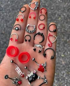 a person's hand with lots of different types of rings and piercings on it