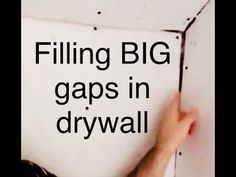 a man is holding a piece of paper with the words filling big gap in drywall