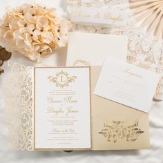 the wedding stationery is laid out on top of the table with flowers and fan