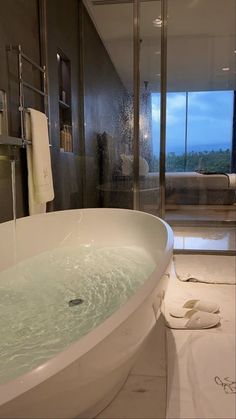 a large bath tub sitting in the middle of a bathroom next to a walk in shower