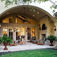 a large house with an arched entrance and lots of greenery on the front lawn