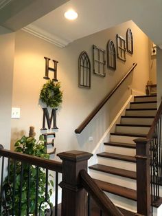 the stairs in this house are decorated with wreaths and monogrammed wall art