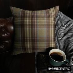 a cup of coffee sitting on top of a table next to a pillow