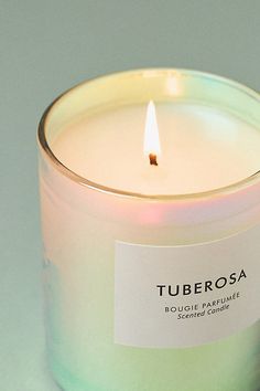 a candle with a label on it sitting in front of a white background and the words tuberosa