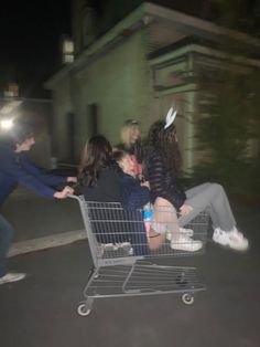 group of people sitting on top of a shopping cart