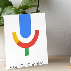 a google logo on a white background art boarder next to a potted plant