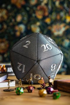 a metal dice sitting on top of a wooden table next to books and other items