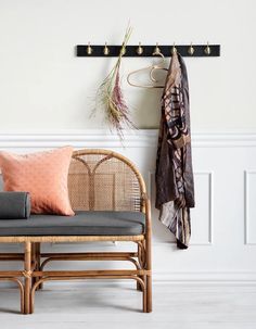 a bench and coat rack in front of a white wall