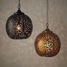 two decorative lights hanging from chains on a wall