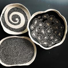 three black and white bowls sitting on top of a table