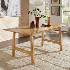 a wooden table sitting on top of a carpeted floor next to a vase filled with flowers