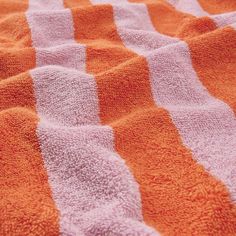 an orange and white striped towel laying on top of a bed