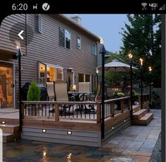 an outdoor patio with lights on the side of it and steps leading up to the back door