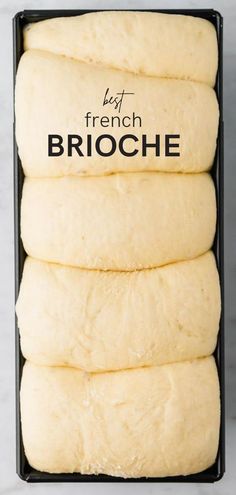 four pieces of bread in a black box on a marble counter top with the words franzosice brioche above it