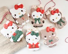 hello kitty cookies are decorated with bows and bowknots on top of a wooden board