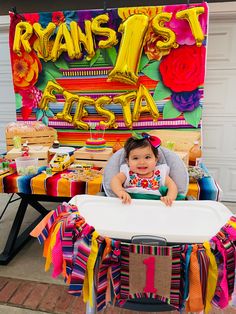 a baby sitting in a highchair at a fiesta themed birthday party