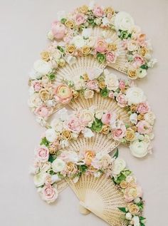 an arrangement of flowers arranged on top of a fan