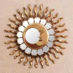 a gold sun shaped mirror hanging on the wall