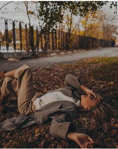 a woman laying on the ground in leaves