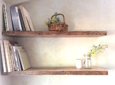 two wooden shelves with books and vases on them