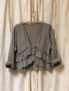 Vintage inspired ruffled linen jacket. Features shell button closures, a double ruffle front, and a flattering neckline. Crop length makes it a versatile piece — wear it over a cami or your favorite dress! Made in the USA. Garment Measurements XXS XS S M L XL Bust 34" 36" 38" 40" 42" 44" Shoulders 13" 14" 15" 16" 17" 18" Length 19" 19" 19" 19" 19" 19" Shabby Chic Fashion, Ruffle Jacket, Autumn 2024, Linen Jacket, Unique Clothing, Romantic Dress, Chic Fashion, Unique Outfits, Jumper Dress