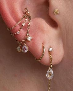 a close up of a person's ear with three different piercings on it