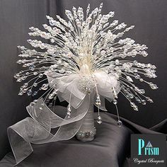 a vase filled with lots of white flowers on top of a black cloth covered table