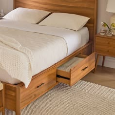 a bed with two drawers underneath it and a blanket on the top of the bed