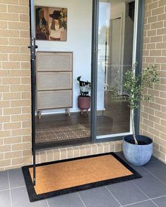 an entryway with a potted plant on the door mat