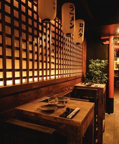 a wooden table sitting in front of a wall with lanterns hanging from it's sides