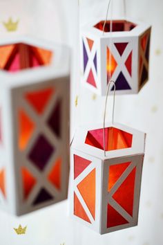 three colorful paper lanterns hanging from strings