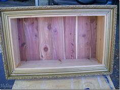 an old frame with wood in it sitting on top of a piece of plywood