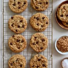 chocolate chip cookies cooling on a wire rack next to bowls of oatmeal