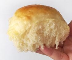 a hand holding a half eaten doughnut in it's left hand on a white background