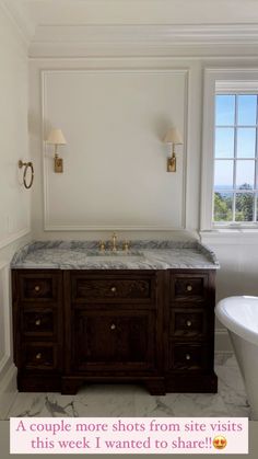 a bathroom with marble counter tops and two gold faucets on the wall next to a bathtub