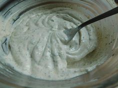 a spoon in a glass bowl filled with mayonnaise