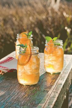 two mason jars filled with lemonade and mint garnish on a wooden table