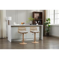 two chairs sitting on top of a wooden floor next to a counter with plants in it