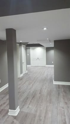 an empty living room with gray walls and wood floors