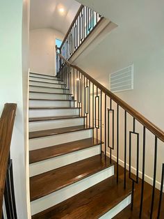 there is a stair case in the house with wood floors and railings on both sides