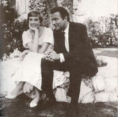 an old black and white photo of a man and woman sitting on a stone bench