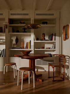 a table and chairs in a room with bookshelves