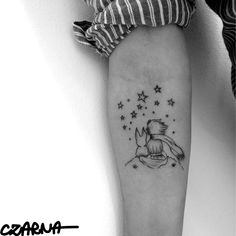 a woman's leg with a small tattoo on it, and stars in the sky