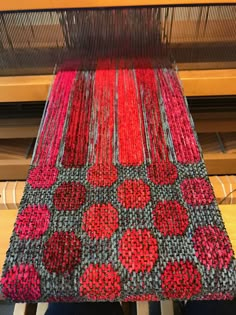 a weaving machine with red and grey circles on it