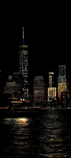 the city is lit up at night and it looks like they are floating in the water