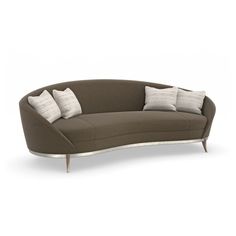 the curved sofa has four pillows on it and is brown with white trimmings