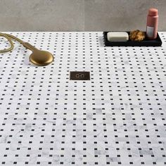 a white table with black and white checkered tiles on it, gold utensils