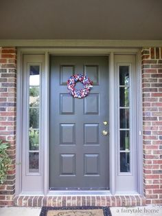 a gray front door with a wreath on it